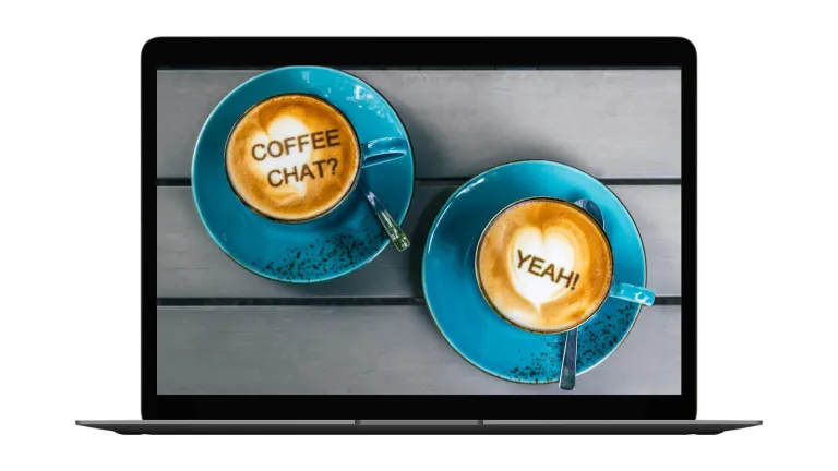 Laptop mit zwei Cappuccino-Tassen auf dem Bildschirm: „Coffee Chat?“ und „Yeah!“